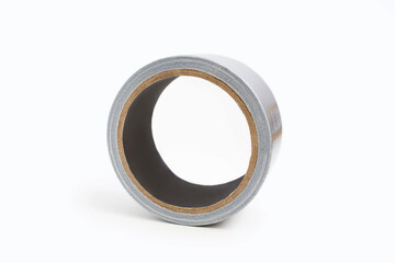 Spool of gray duct tape on a white background in the center of the image. Adhesive tape for repair work and cable communications. Adhesive tape for moisture protection or for assembly and packaging