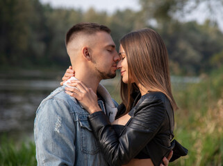 Fototapeta premium hugging couple walking in the autumn park near lake