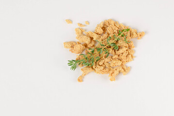 Macro photo of pieces textured soy protein or alternative meat with thyme isolated on white background