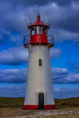 White lighthouse with a red head on the beach of Sylt.
