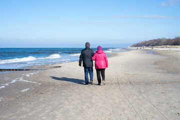 Elderly couple take a walk together at the Baltic Sea in winter