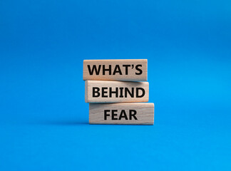 What's behind fear symbol. Concept words What's behind fear on wooden blocks. Beautiful blue background. Business and What's behind fear concept. Copy space.