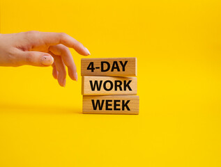 4-day work week symbol. Concept words 4-day work week on wooden blocks. Beautiful yellow background. Businessman hand. Business and 4-day work week concept. Copy space