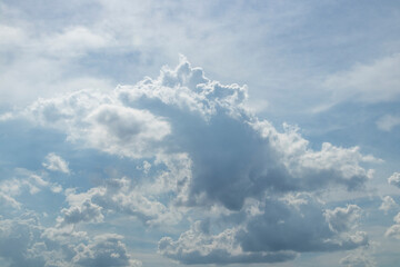Blue sky with fluffy clouds that look like dinosaur or fire breathing dragon