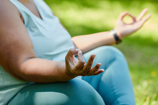 Close Up Of Overweight Black Woman Doing Yoga Outdoors And Meditating With Focus On Hand Pose, Copy Space