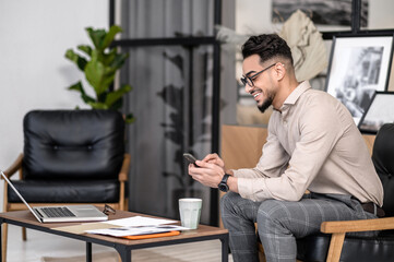 Man sitting sideways to camera looking at smartphone