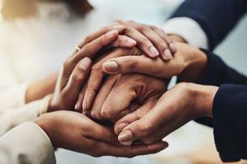 Business people holding hands for support, motivation and comfort together at work. Closeup of group of professional employees, colleagues and workers joining hands for help, consoling and community
