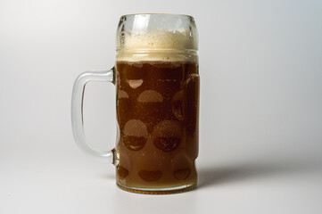 glass transparent beer mug of dark beer isolated on a light background