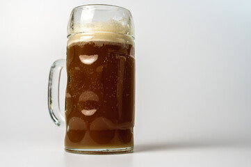 glass transparent beer mug of dark beer isolated on a light background