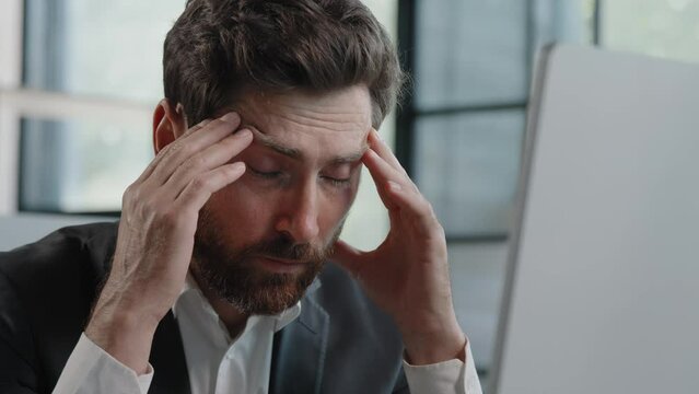 Ill tired frustrated Caucasian bearded 40s business man worker upset sad manager feel stressed look at computer screen suffer from lost job bad news worried of problem failed startup trouble in office