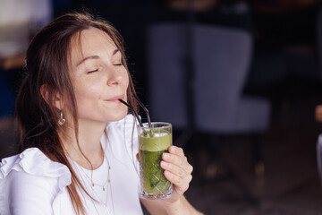 girl drink healthy fresh cocktail in modern cafe