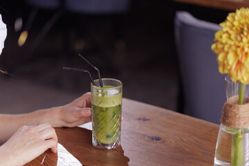 girl drink healthy fresh cocktail in modern cafe