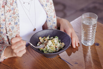 girl eating healthy salad close-up in a modern restaurant