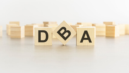 word DBA is made of wooden blocks on white background