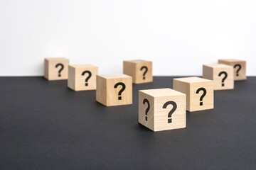 front view on many wood cubes with question marks. many question arising concept