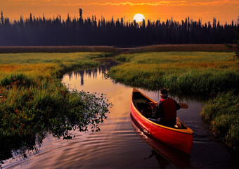 A red canoe at sunrise navigating a small stream that leads to Hosmer lake near Bend, Oregon