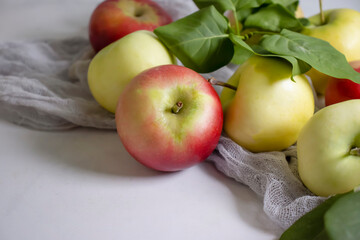 Fresh apples with leaves on a light background