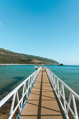 A small pier in a blue water beach in Arrabida National Park in Portugal