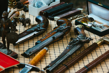 Collection of antique weapons at the flea market. Sale of antiques at a street shop