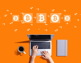 Bitcoin theme with person using a laptop computer