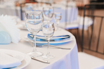 empty wine glasses on a round table with a white tablecloth. 