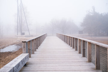 Walking path in the park during heavy fog. Weather conditions and changes