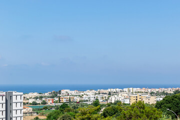 Fototapeta na wymiar View of the city and the sea. Paphos, Cyprus. Green in the city and clear blue sea.