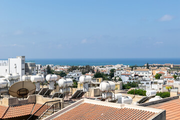 View of the city and the sea. Paphos, Cyprus. Water tanks on the roofs of houses.