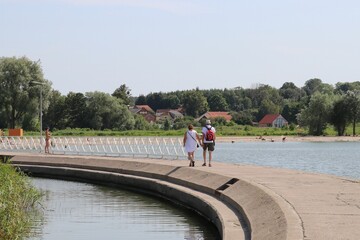 Turyści spacerujący po falochronie w zatoce