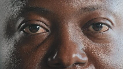 Extreme close up african male face in detail adult man model client of ophthalmology with dark skin tired unhealthy eyesight vision problems after hard computer work opens eyes laser correction lenses