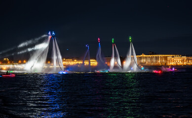 A lot of flyboarders and brightly dressed up jet skiers perform their show at a holiday in the...