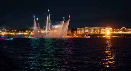 Fototapeta na wymiar A lot of flyboarders and brightly dressed up jet skiers perform their show at a holiday in the center of St. Petersburg at night, water activities
