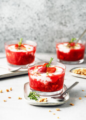 Sweet strawberry puree and cream cheese dessert decorated with fresh berries, granola and sprig of thyme in glasses. Homemade healthy food concept.