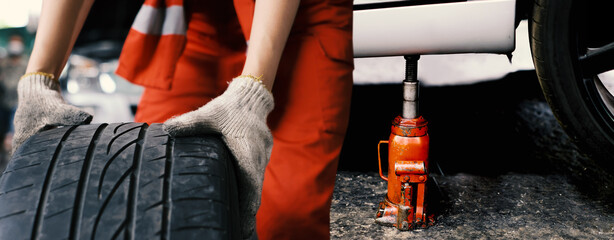 The red hydraulic bottle jack is installed under the machine and lifting it. Hydraulic car jack...