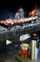 Cocinando asado argentino y tomando mate.