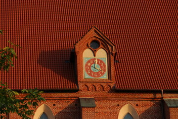 Zegar na gotyckim budynku z czerwonym dachem - obrazy, fototapety, plakaty