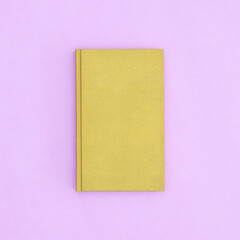 Green hardcover vintage book on pastel purple background. Flat lay copy space