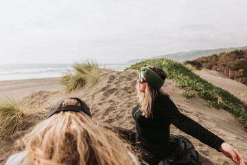 Two girls relaxing and sitting on the beach. Overcoming depression