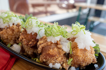 Japanese style crispy fried chicken, Karaage with rice and salad on outdoor wooden table.