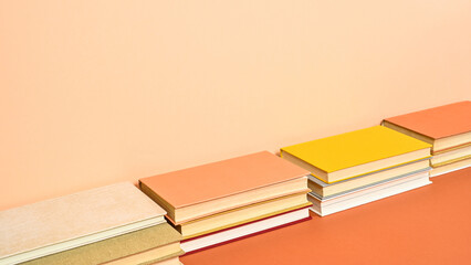 Creative hardcover vintage books on two shade orange background. Flat lay