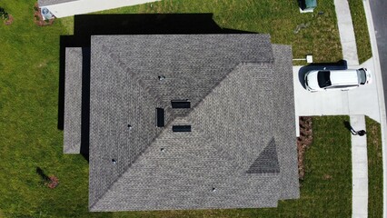 aerial drone photo of roof of modern house with white car in drive way  © christian.bitzas