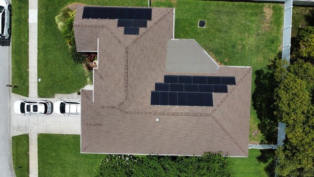 Aerial drone photo of solar panels on shingle roof of modern family home in Florida