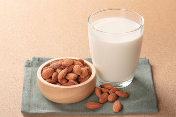 Glass of almonds milk with almond on wooden table.