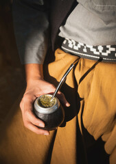 Argentinian gaucho holding a mate with traditional clothings