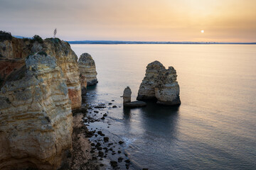 Landscape with rocks and sea stacks at Ponta da Piedade, Lagos, Algarve (Portugal) at sunrise.