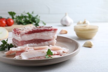 Tasty salt pork with parsley on white wooden table
