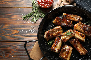 Delicious grilled ribs served on wooden table, flat lay