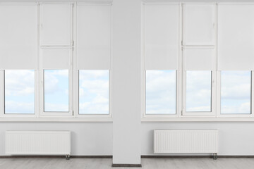 Plastic windows with white roller blinds indoors