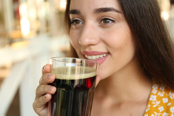 Beautiful woman with cold kvass outdoors, closeup. Traditional Russian summer drink
