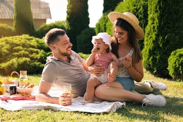 Happy family having picnic in garden on sunny day